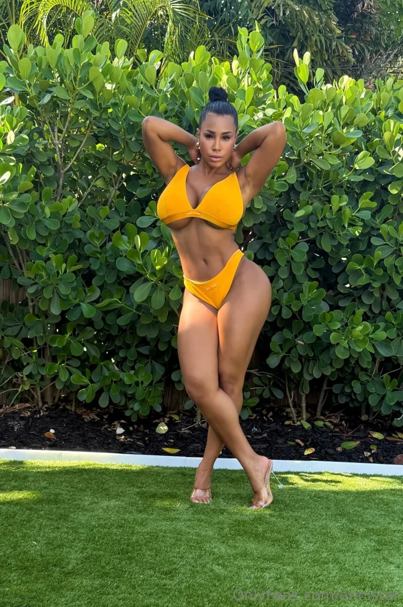 Flirty Anni Star in yellow bikini posing with hands behind head on grass