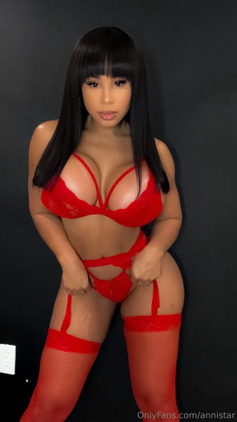 Sultry Anni Star in red lace lingerie and fishnets, spreading her legs for the camera