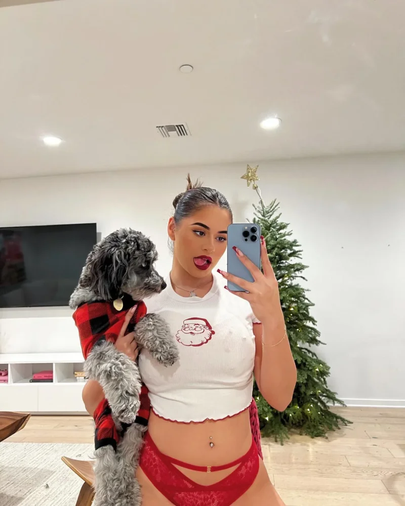 Seductive Noelia Ramirez in red lace underwear holds a dog while taking a mirror selfie