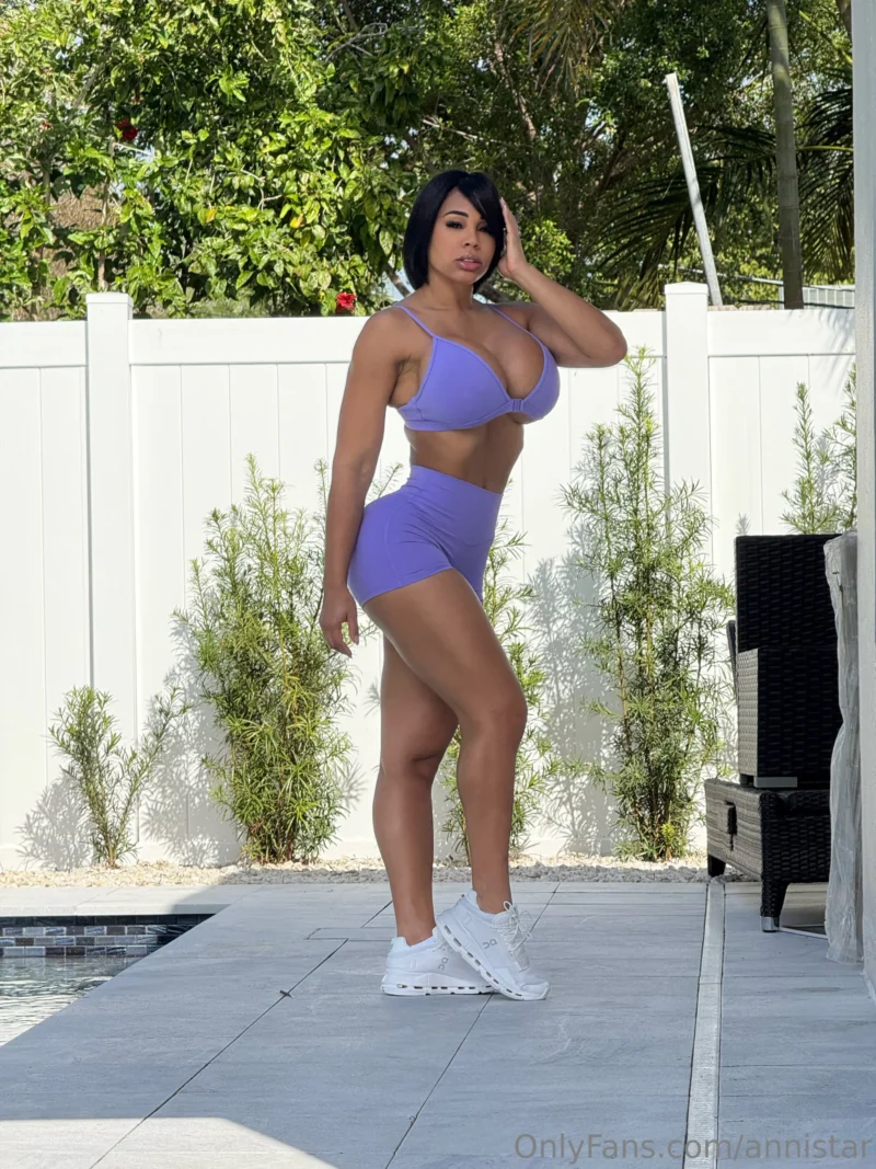 Hot Anni Star in purple sports bra and shorts posing by poolside, hand in hair