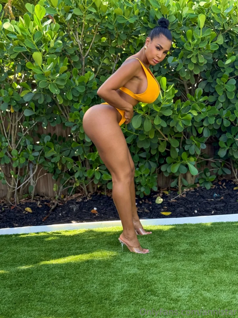 Curvy Anni Star in yellow bikini bends over showing her ass on green grass