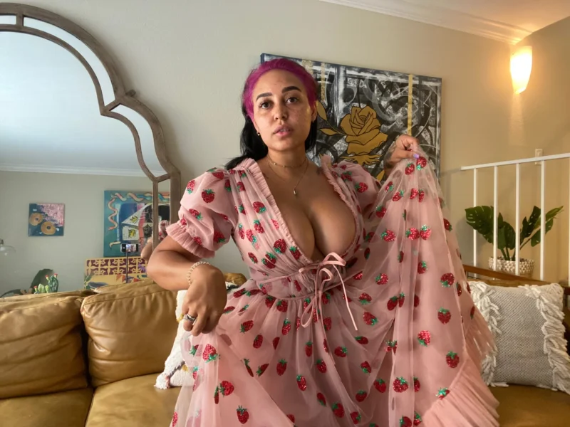 Naughty Emily Cheree in pink strawberry dress flashing her tits on couch