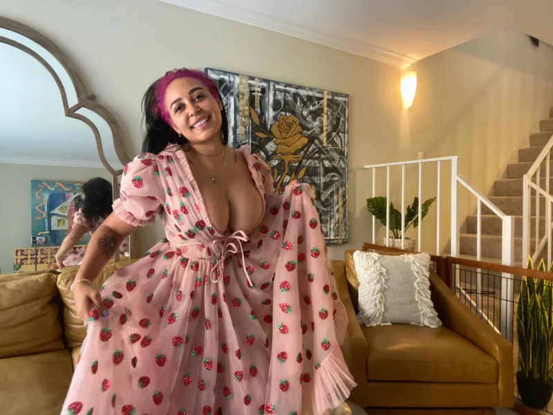 Flirty Emily Cheree in pink strawberry dress flashing her tits in living room