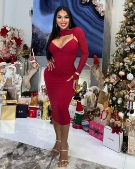 Busty Dolly Castro in a tight red dress posing by a Christmas tree with gifts