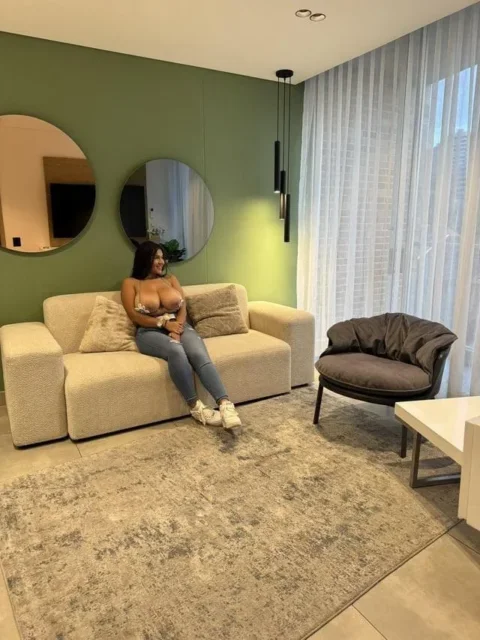 porn photo of Dasani Delgado sitting on couch in jeans with big tits out