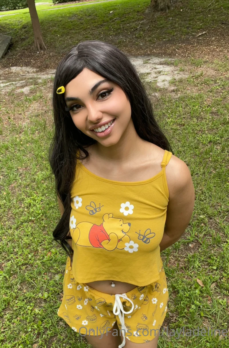 Seductive Layla Deline smiling in a yellow Winnie the Pooh crop top and shorts outdoors