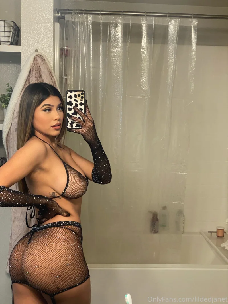 Hot lildedjanet in sparkly fishnet lingerie taking a mirror selfie in the bathroom
