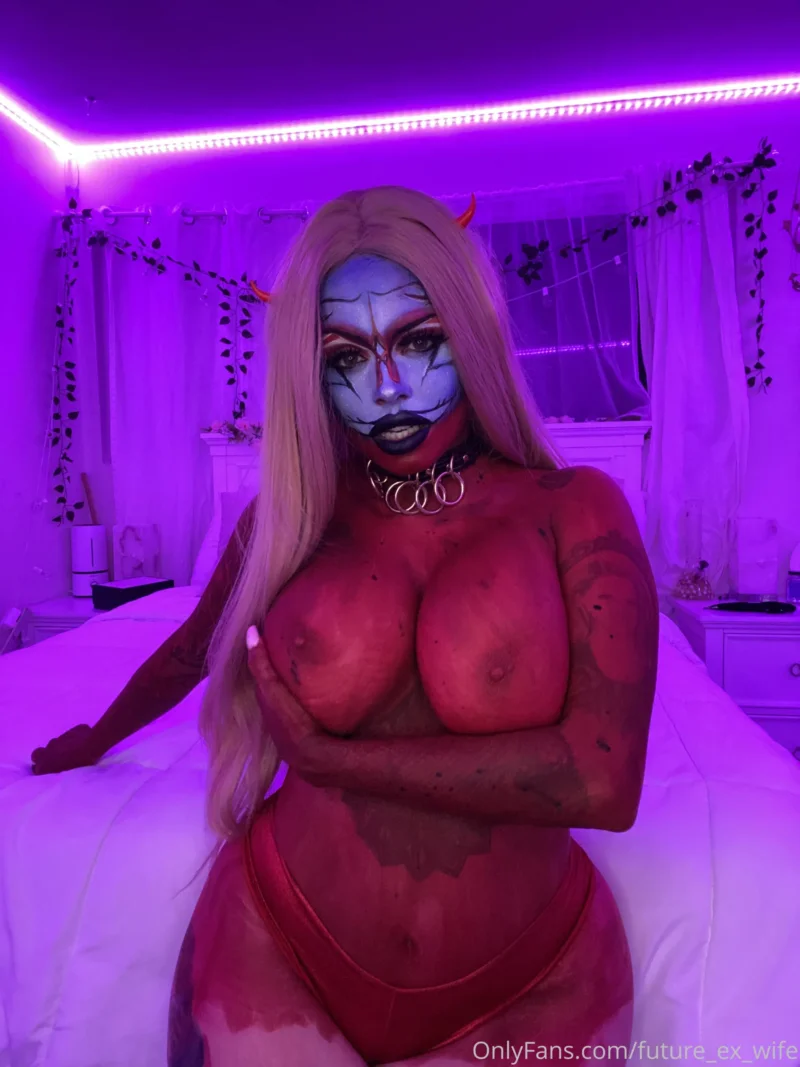Busty future_ex_wife in devil cosplay with blue face paint, red body paint, and horns on a bed