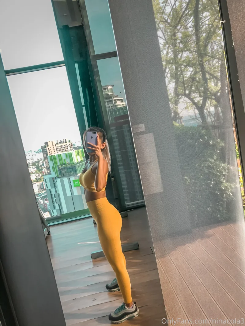 Seductive Nina cola in yellow sports bra and leggings takes mirror selfie by window with city view