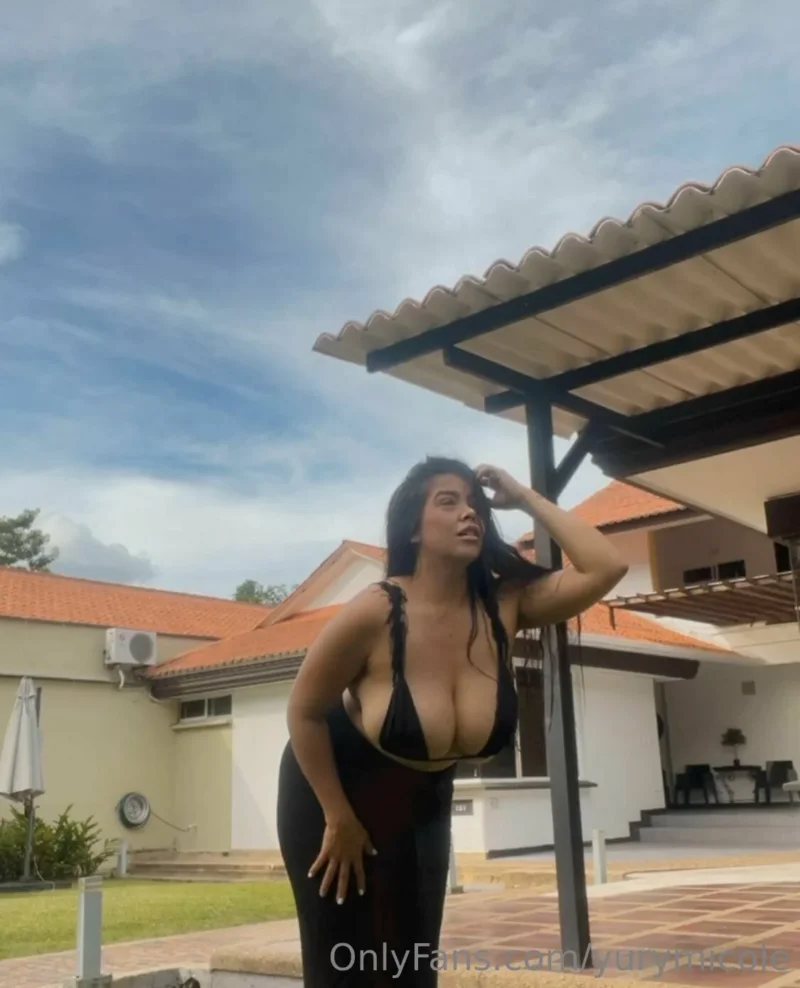 Seductive Yury Micole in black lingerie posing outdoors with one hand in her hair
