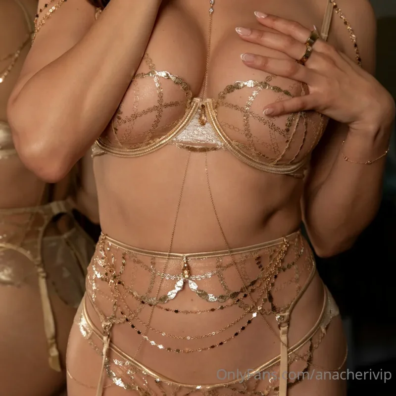 Naughty Ana Cheri in gold lace lingerie touching her big tits